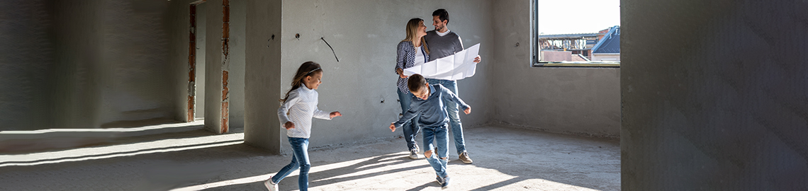 Glückliche Familie analysiert Pläne in ihrer neuen Wohnung